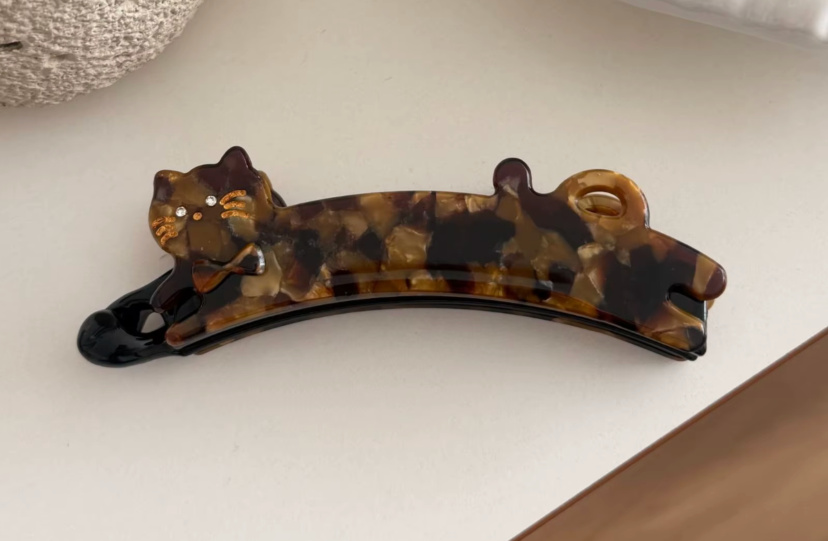 Hårklämma (bananklämma)-utsträckt katt, finns i tre olika varianter