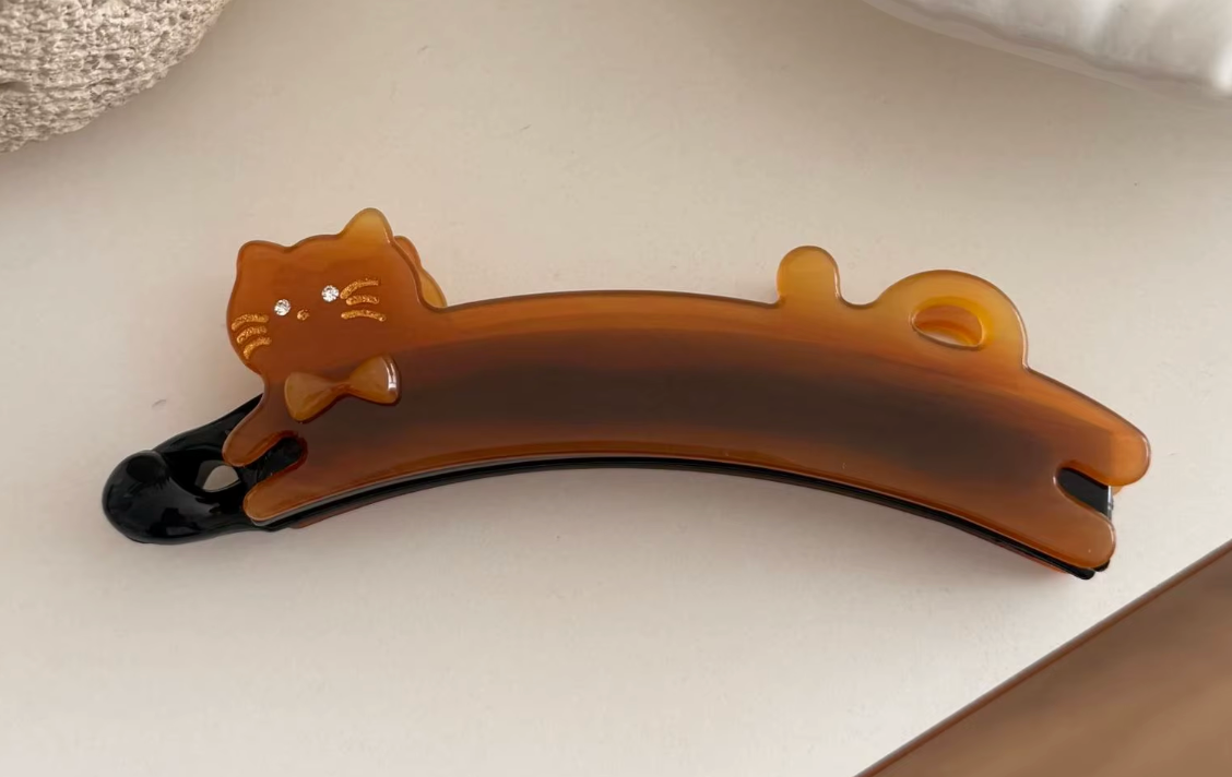 Hårklämma (bananklämma)-utsträckt katt, finns i tre olika varianter